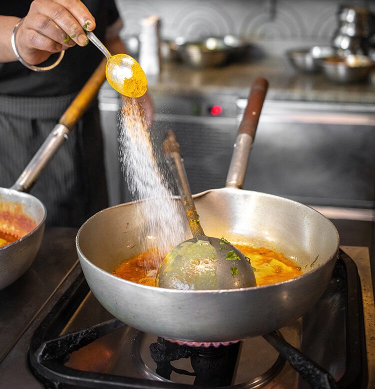 curry dish prepared in a pan, cooking in an Indian restaurant