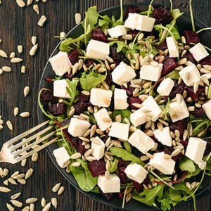 Healthy beetroot salad with feta cheese, arugula and sunflower seeds.